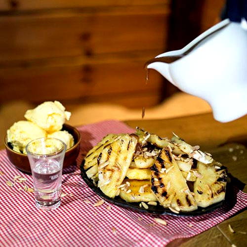 Grilled pineapple with caramel sauce, ice cream and roasted almonds